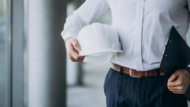 Handsome business man engineer in hard hat in a building